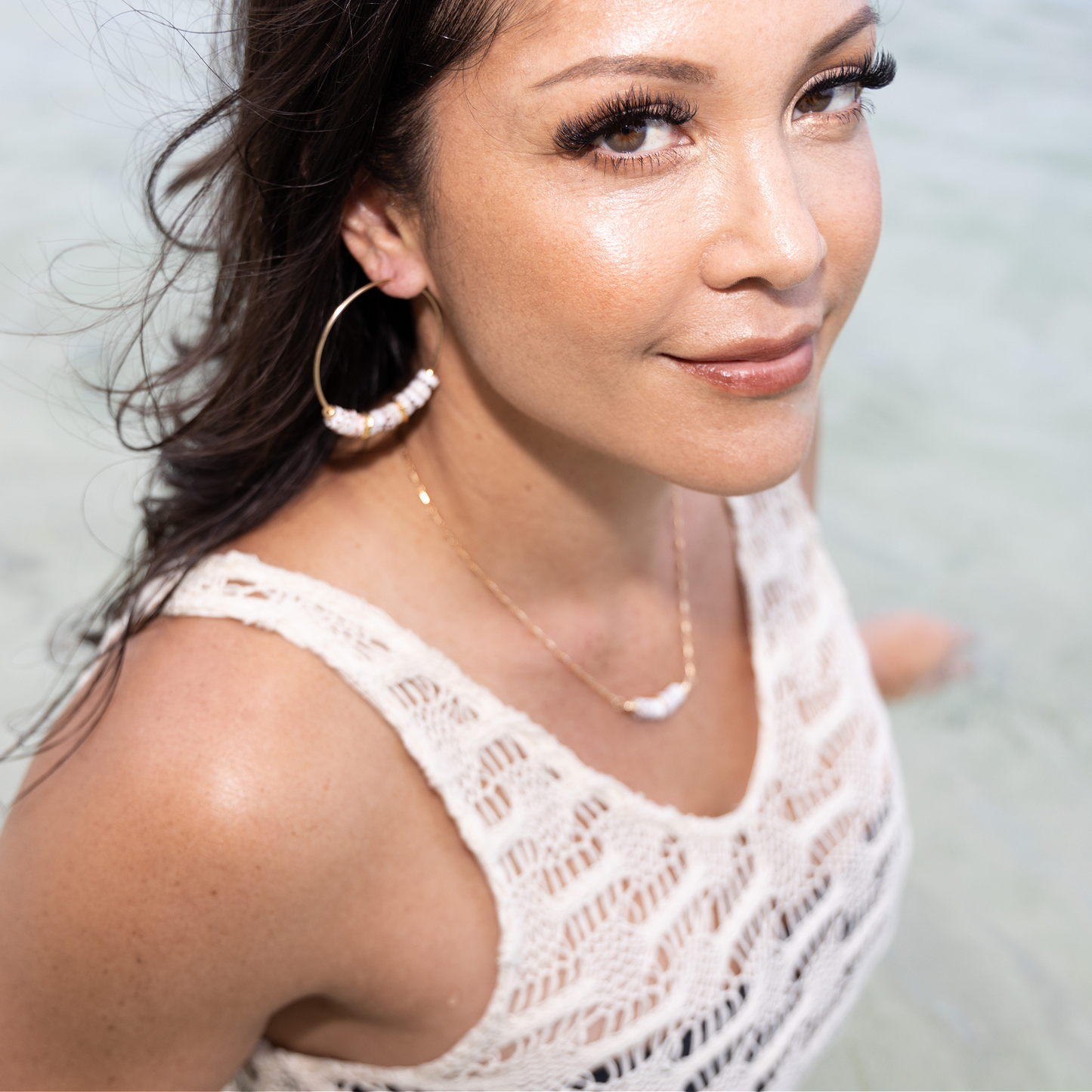 Beautiful Hawaiian woman  on a beach looking at the camera wearing puka shell necklace and hoop earrings Pukanui Hoop Earrings - 21 Degrees North Designs - 21ºN